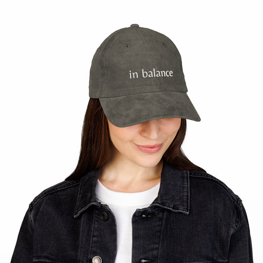 Person wearing a gray cap with 'in balance' text on a white background